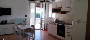 a kitchen with a small table and a kitchen with white cabinets at La casa di Gergy in Borgomanero