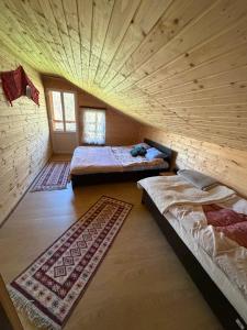 an attic room with two beds and a ceiling at Cabana Buta in Dumeşti
