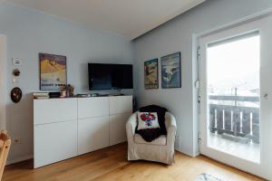 a living room with a chair and a television at Appartement SISI by MoniCare in Seefeld in Tirol