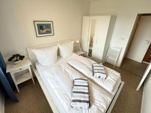a bedroom with a white bed with two towels on it at Ferienwohnung-20-A139 in Westerland