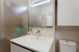 a bathroom with a white sink and a mirror at Appartement SISI by MoniCare in Seefeld in Tirol