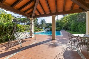 a patio with a table and chairs and a swimming pool at Villa Alberta With Reserved Beach Spot in Marina di Massa