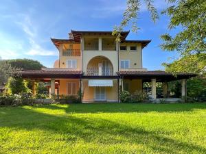 a large house with a green lawn in front of it at Villa Alberta With Reserved Beach Spot in Marina di Massa