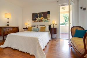 a bedroom with a white bed and a couch at Villa Alberta With Reserved Beach Spot in Marina di Massa +129 photos
