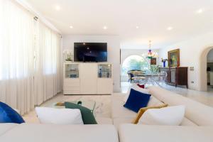 a living room with white furniture and a tv at Villa Alberta With Reserved Beach Spot in Marina di Massa