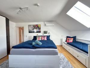 a bedroom with a large white bed with blue sheets at Charly`s Place in Rain +9 photos