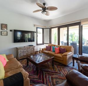 a living room with two couches and a tv at Marassi Stand alone luxury villa in El Alamein