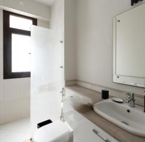 a white bathroom with a toilet and a sink at Marassi Stand alone luxury villa in El Alamein +18 photos