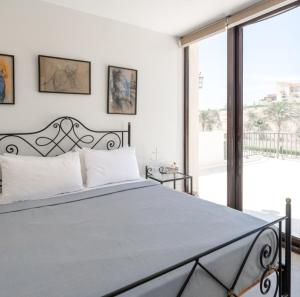 a bedroom with a bed and a large window at Marassi Stand alone luxury villa in El Alamein
