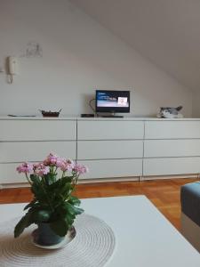 a living room with a vase with flowers on a table at Apartman Skyview in Požarevac