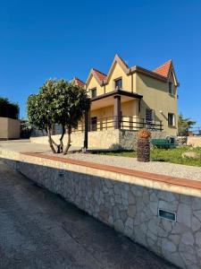 a house with a stone wall next to a street at Villa Vittoria Relais in Venosa