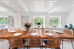 a dining room with a large wooden table and chairs at Carolinenhof-1 in Tinnum