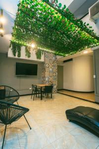 a room with a table and chairs and a tv at Mandala Medellín Belén By GyC Hotels in Medellín