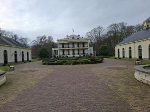 a large white house with a courtyard in front of it at Dromen op de Veluwe in Putten