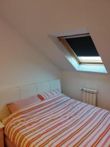 a small bedroom with a bed with a window at Apartman Skyview in Požarevac