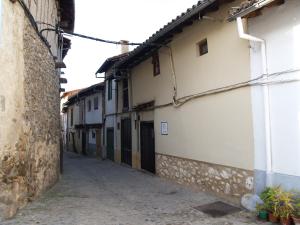 un callejón en un casco antiguo con edificios blancos en La casa del Vado en Hervás