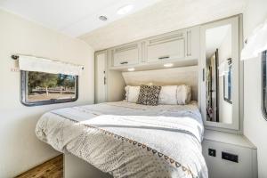 a bedroom of an rv with a bed and a window at De Anza Springs Resort in Titus