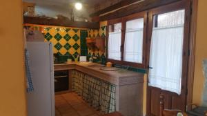 a kitchen with a counter and a refrigerator at Casa El Pajar De Tasio in San Miguel del Pino