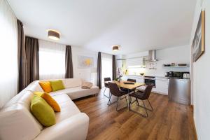 a living room with a white couch and a table at Pension Hofer in Brunico