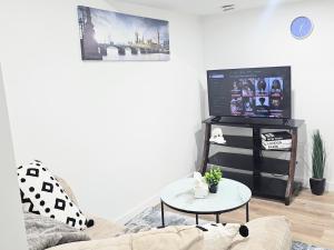 a living room with a tv and a table at Snug 2 bedroom sleeps 5-Netflix in Edmonton