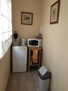 uma pequena cozinha com frigorífico e micro-ondas em Delaporte em Béziers