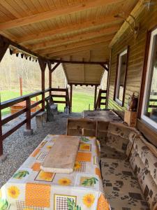 a covered porch with a table and a bed at Cabana Buta in Dumeşti +17 photos