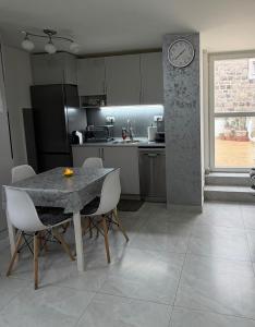 a kitchen with a table and chairs and a clock at Lili's Sea View in Budva
