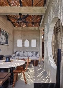 a room with couches and a table and chairs at Orama Bali in Uluwatu