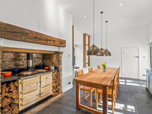 a kitchen with a wooden table and a kitchen with a stove at Chantry in Kingsbridge