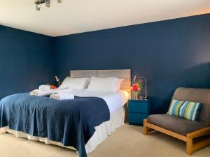 a blue bedroom with a bed and a chair at Chantry in Kingsbridge