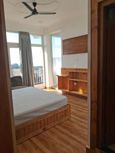 a bedroom with a bed and a ceiling fan at Nanda niwas 2 in McLeod Ganj +4 photos