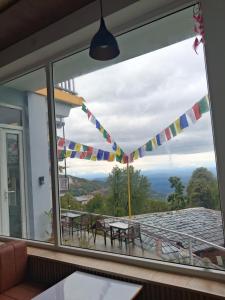 a window with a view of a table and chairs at Nanda niwas 2 in McLeod Ganj