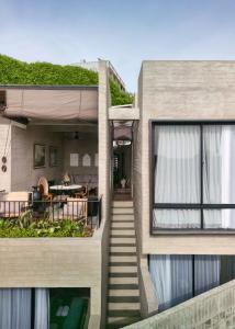 a house with a staircase leading up to a patio at Orama Bali in Uluwatu