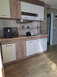 a kitchen with white cabinets and a microwave at Sap Pool House in Ritopek