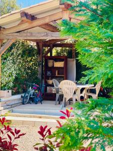 a wooden pergola with a table and chairs in a garden at Maison in Fayence