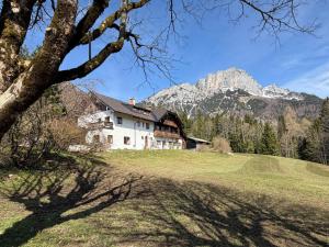 a house in a field with mountains in the background at Nusshof in Berchtesgaden