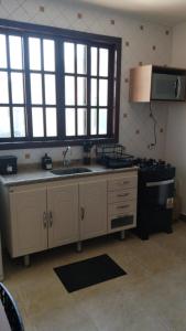 a kitchen with a sink and a stove at Casa da Dinda 203 in Rio das Ostras