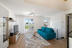 a living room with a blue couch and a tv at Exceptional stone character house Chalet Prazeres in Prazeres