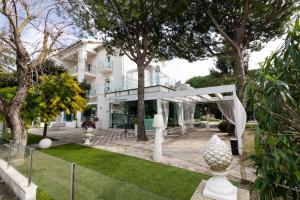 a white house with trees and a yard at Villa Liliana in Cervia