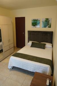 a bedroom with a large bed with a black headboard at Casa Esperanza in Cali