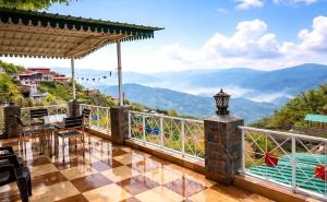 a house with a balcony with a view of mountains at Balcony in the Clouds - Himalayan Views, Sunset in Rāmgarh