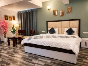 a bedroom with a large bed and a table and chairs at Balcony in the Clouds - Himalayan Views, Sunset in Rāmgarh