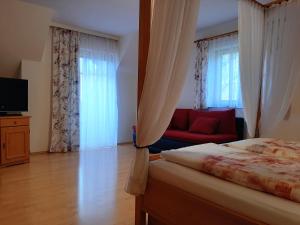 a bedroom with a bed and a red couch at Ferienhaus Zotter in Feldbach