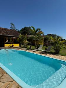a large blue swimming pool in front of a house at Chalé Ipê Amarelo in Juquitiba