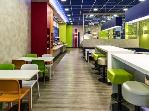 a restaurant with white tables and green chairs at ibis budget RJ Praia de Botafogo in Rio de Janeiro