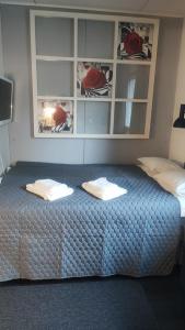 a bedroom with a bed with two towels on it at Hartikkalan Apartments in Lappeenranta