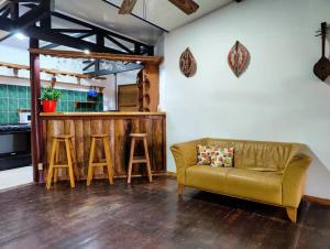 a living room with a couch and two stools at Ocean Breeze Beach Front Apartment with AC in Puerto Viejo