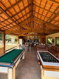 a large room with a pool table and couches at Chalé Ipê Amarelo in Juquitiba