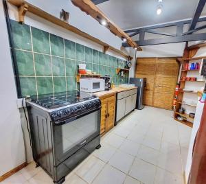a kitchen with a stove and a microwave at Ocean Breeze Beach Front Apartment with AC in Puerto Viejo +12 photos