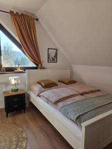 a bedroom with a large bed with a window at Jagodowa Czulnia in Zwierzyń